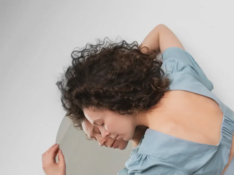 images/blog/high-angle-woman-laying-mirror.webp